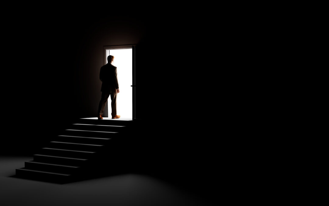 silhouette standing in front of open door representing new beginning in mental health recovery